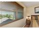 Bedroom with view through wooden blinds, beside a wooden night table with lamp and a bed with patterned bedspread at 11800 Buttonhook Dr, Clermont, FL 34711