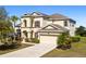 Elegant two-story home with manicured landscaping, arched entryways, and two-car garage at 11800 Buttonhook Dr, Clermont, FL 34711