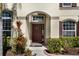 Inviting entryway with a charming dark wood door and well-maintained landscaping at 11800 Buttonhook Dr, Clermont, FL 34711