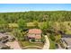 An aerial view of a home with a tile roof, surrounded by lush greenery and a serene pond at 1185 Cypress Loft Pl, Lake Mary, FL 32746