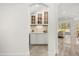 Butler's pantry with white cabinets, countertop, and view of the bright living area at 1185 Cypress Loft Pl, Lake Mary, FL 32746