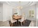 Elegant dining room with tray ceiling, chandelier, wood table, and shuttered windows at 1185 Cypress Loft Pl, Lake Mary, FL 32746