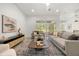 Cozy living room featuring stylish seating, a modern entertainment center, and seamless access to outdoor spaces at 1185 Cypress Loft Pl, Lake Mary, FL 32746