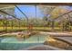 Relaxing screened-in pool and spa overlooking a serene pond and lush greenery, perfect for outdoor enjoyment at 1185 Cypress Loft Pl, Lake Mary, FL 32746