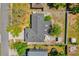 Aerial view of the home showing a dark gray roof, fenced in yard, mature trees, and an umbrella on the patio at 1259 Freeport Dr, Deltona, FL 32725