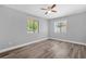 Neutral bedroom features wood-look flooring, ceiling fan, and two sun-filled windows at 1259 Freeport Dr, Deltona, FL 32725