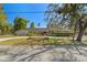 Well-maintained one-story home with an American flag, manicured lawn, and mature trees creating a serene setting at 1285 Seminole Ave, Longwood, FL 32750