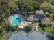 Aerial view showcasing a pool, tennis court, and clubhouse surrounded by mature trees and lush landscaping at 2202 Clubside Dr # 2202, Longwood, FL 32779