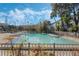 Community pool surrounded by lounge chairs, lush landscaping and palm trees under a partly cloudy sky at 2202 Clubside Dr # 2202, Longwood, FL 32779