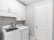 Bright laundry room with white cabinets, washer, and dryer for convenient chores at 2258 Ardon Ave, Orlando, FL 32833