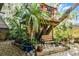 Landscaped backyard featuring a wooden bench, a raised platform, and tropical plants at 2606 Teeside Ct, Kissimmee, FL 34746