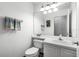 Bright bathroom featuring a toilet, white sink, large mirror, and vanity with chrome hardware at 2606 Teeside Ct, Kissimmee, FL 34746