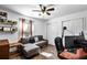 This bedroom features light walls, dark floors, a ceiling fan, a small sofa, and a desk at 2606 Teeside Ct, Kissimmee, FL 34746