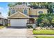 Two-story home featuring a large garage, desert landscaping, and a mix of stone and siding accents at 2606 Teeside Ct, Kissimmee, FL 34746