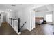 Hallway with dark wood floors leads to a bedroom, with a white railing and black spindles at 2606 Teeside Ct, Kissimmee, FL 34746