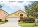 Charming two-story home featuring a well-manicured lawn, colorful shrubbery, and an attached two-car garage at 2787 Lido Key Dr, Kissimmee, FL 34747