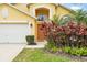 Two-story home featuring a lush, colorful front yard, two car garage, and classic architectural details at 2787 Lido Key Dr, Kissimmee, FL 34747