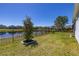 The backyard overlooks a serene pond, enhanced by a black fence and beautifully manicured landscaping at 430 Brunswick Dr, Davenport, FL 33837