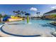 View of community pool with splash fountain, zero entry, and lounge seating and umbrellas at 430 Brunswick Dr, Davenport, FL 33837