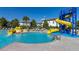 View of community pool featuring blue and yellow water slides with surrounding lounge chairs at 430 Brunswick Dr, Davenport, FL 33837