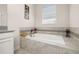 Clean bathroom showcasing a built-in tiled soaking tub with modern fixtures and a decorative tiled accent at 430 Brunswick Dr, Davenport, FL 33837