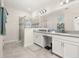 Bright main bathroom featuring double sinks, a makeup vanity, tiled floors, and a glass-enclosed shower at 430 Brunswick Dr, Davenport, FL 33837