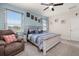 Well-lit main bedroom with a queen bed, a sitting chair, large windows, and a ceiling fan at 430 Brunswick Dr, Davenport, FL 33837