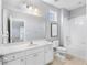 Bathroom features a white vanity, toilet, shower and tub with tile surround, and a large mirror at 4416 Shiva Loop, Kissimmee, FL 34746