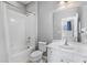 Well-lit bathroom with white tile, vanity, and shower-tub combination at 4416 Shiva Loop, Kissimmee, FL 34746