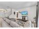 Bright living room featuring a gray sofa, a modern TV console, and neutral tile flooring at 4416 Shiva Loop, Kissimmee, FL 34746