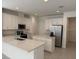 Modern kitchen with white cabinets, stainless steel appliances and a center island at 5111 Lake Hamlin Trl, Winter Garden, FL 34787