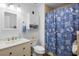 Cozy bathroom with a vanity, toilet, shower with blue seashell curtain, and matching decor elements at 516 Donaldson Dr, Debary, FL 32713