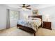 Bright bedroom featuring a ceiling fan, neutral carpet, and a large bed with a floral comforter at 516 Donaldson Dr, Debary, FL 32713