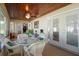 Inviting sun room with wood ceiling, white wicker seating, and multiple glass doors for outdoor access at 516 Donaldson Dr, Debary, FL 32713