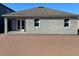 Exterior shot of the back of a home with an unfinished backyard and a covered patio area at 5738 Cattle Ranch Dr, St Cloud, FL 34771