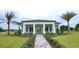 Inviting exterior view of a clubhouse featuring a well-manicured lawn and palm trees at 5738 Cattle Ranch Dr, St Cloud, FL 34771