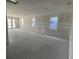 Spacious unfinished living room featuring newly-installed drywall, large windows, and a sliding door to a patio at 5738 Cattle Ranch Dr, St Cloud, FL 34771