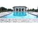 Relaxing community pool area with a cabana featuring columns and a stone-paved deck at 5738 Cattle Ranch Dr, St Cloud, FL 34771