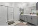 Bright bathroom featuring a glass-enclosed shower and double vanity with gray cabinets and white countertops at 588 Hitch Loop, St Cloud, FL 34772