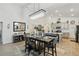 Open-concept dining room with modern lighting fixture, table setting, and adjacent kitchen at 588 Hitch Loop, St Cloud, FL 34772