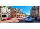 Vibrant street scene with palm trees, parked cars, and colorful buildings in a bustling neighborhood at 611 Campus St # 320, Kissimmee, FL 34747