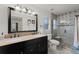 Bright bathroom featuring a double sink vanity with granite counters and a glass enclosed shower with tile accents at 651 Robinhood Dr, Maitland, FL 32751