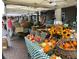 Outdoor farmer's market stand with fresh produce, flowers, and people shopping at 651 Robinhood Dr, Maitland, FL 32751