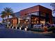 Nighttime view of a modern restaurant with large windows, showcasing a lively interior and outdoor seating at 651 Robinhood Dr, Maitland, FL 32751