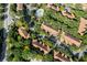 An aerial shot of the neighborhood highlighting lush trees, townhome roofs and community pool at 6847 Sperone St, Orlando, FL 32819