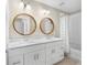 Bathroom features dual sinks, wood framed round mirrors, and shower with patterned curtain at 6847 Sperone St, Orlando, FL 32819