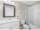 Bathroom vanity with single sink, framed mirror, toilet and shower with patterned curtain at 6847 Sperone St, Orlando, FL 32819