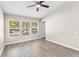 Bedroom showcasing bright windows, ceiling fan and wood-look flooring at 6847 Sperone St, Orlando, FL 32819