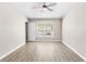 Neutral bedroom with natural light, ceiling fan and wood-look flooring at 6847 Sperone St, Orlando, FL 32819