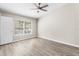 Bright bedroom featuring wood-look floors, a ceiling fan, and a large window at 6847 Sperone St, Orlando, FL 32819